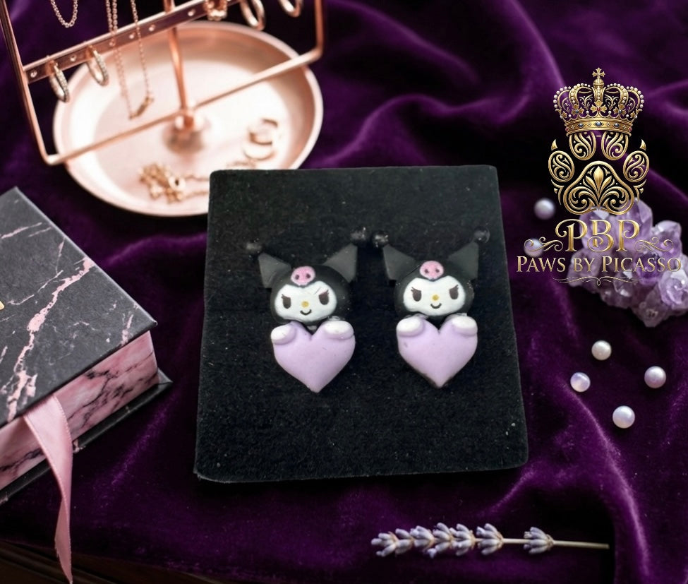 Cat shaped earrings on a dark surface