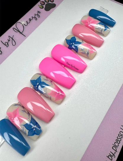 Set of pink, blue, and white nails with floral designs on a white background.
