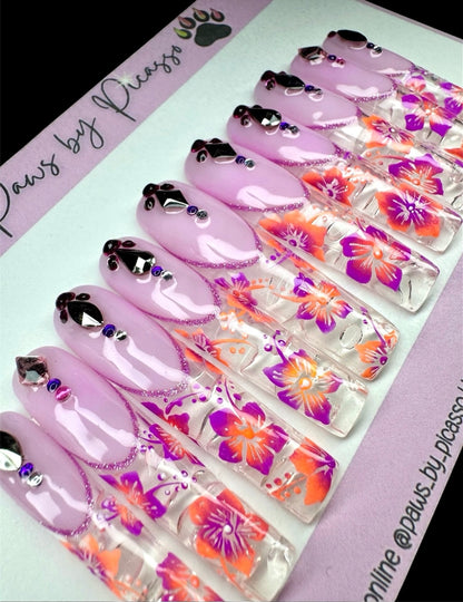 Set of purple nail art designs with floral patterns on a branded card.