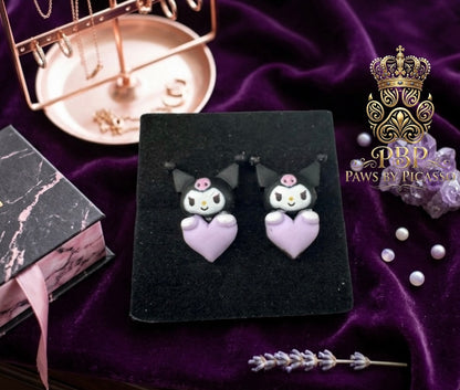 Cat shaped earrings on a dark surface 